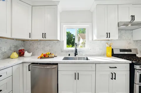 a kitchen with stainless steel appliances granite countertop a sink a stove and cabinets