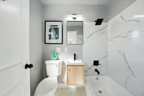 a bedroom with a bed and painting on the wall