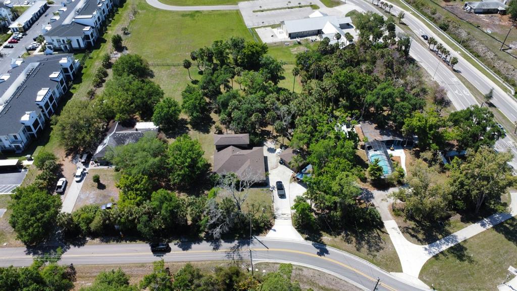 an aerial view of residential house with outdoor space and trees all around