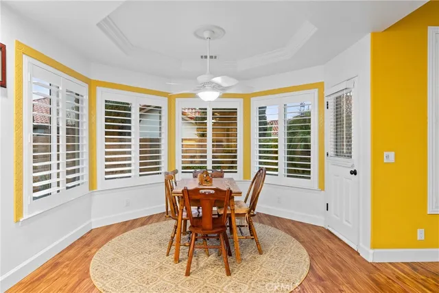 a dining room with furniture a chandelier and wooden floor