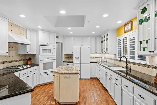 a large kitchen with stainless steel appliances kitchen island granite countertop a sink and cabinets