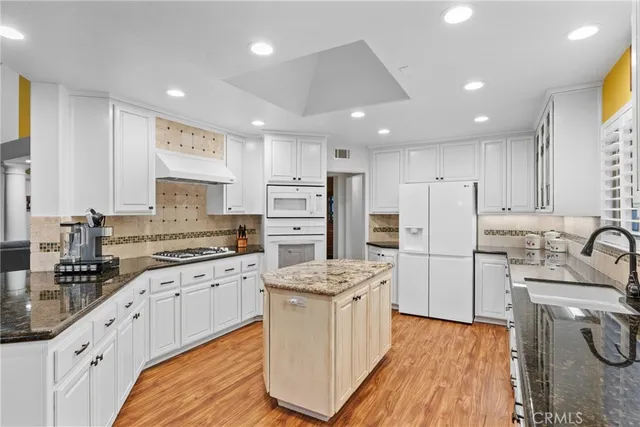 a kitchen with white cabinets sink and stainless steel appliances