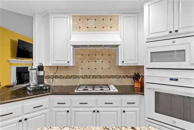 a kitchen with granite countertop a stove a sink and a microwave