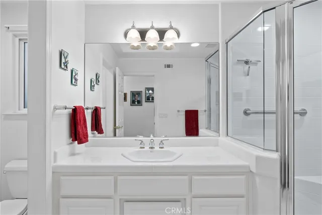 a bathroom with a sink vanity mirror and shower