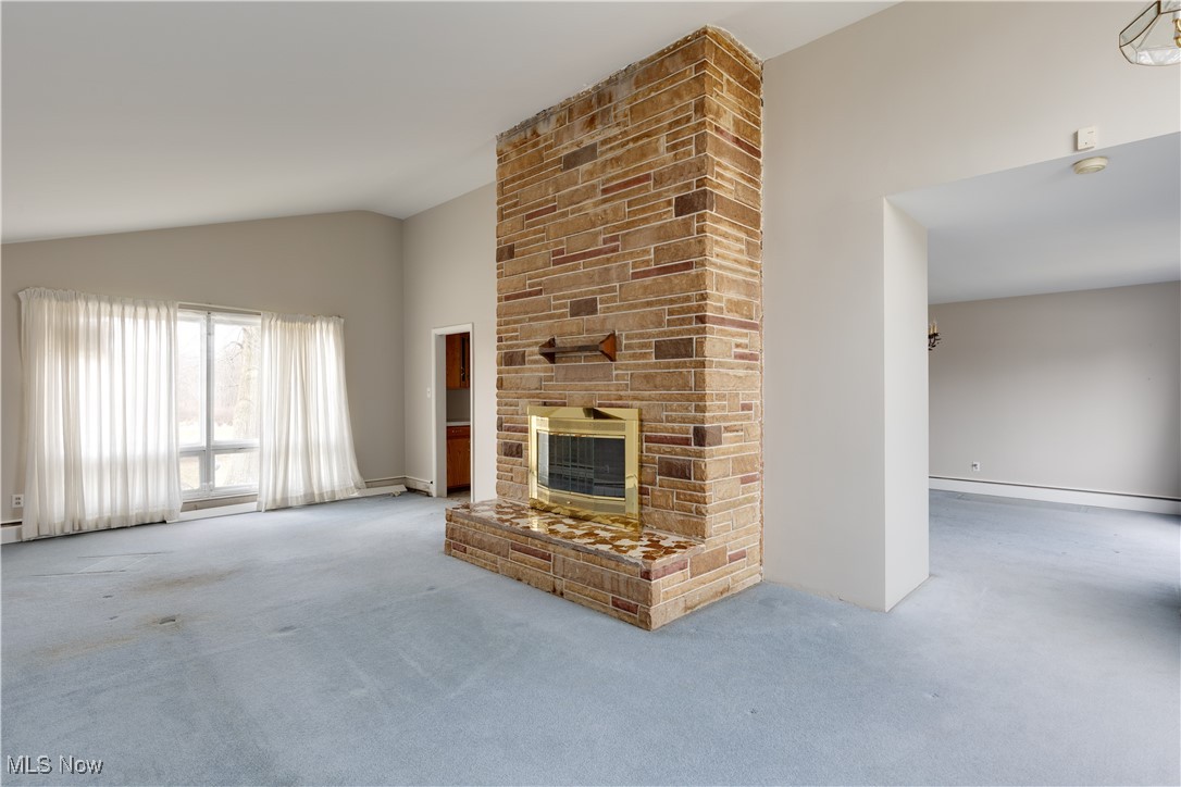 1847 Conley Road Mogadore, OH 44260 - Photo 3 of 42 Living room featuring carpet floors, a fireplace, and vaulted ceiling