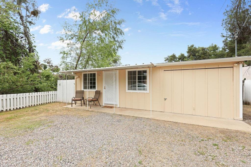 a view of a house with a small yard and wooden fence