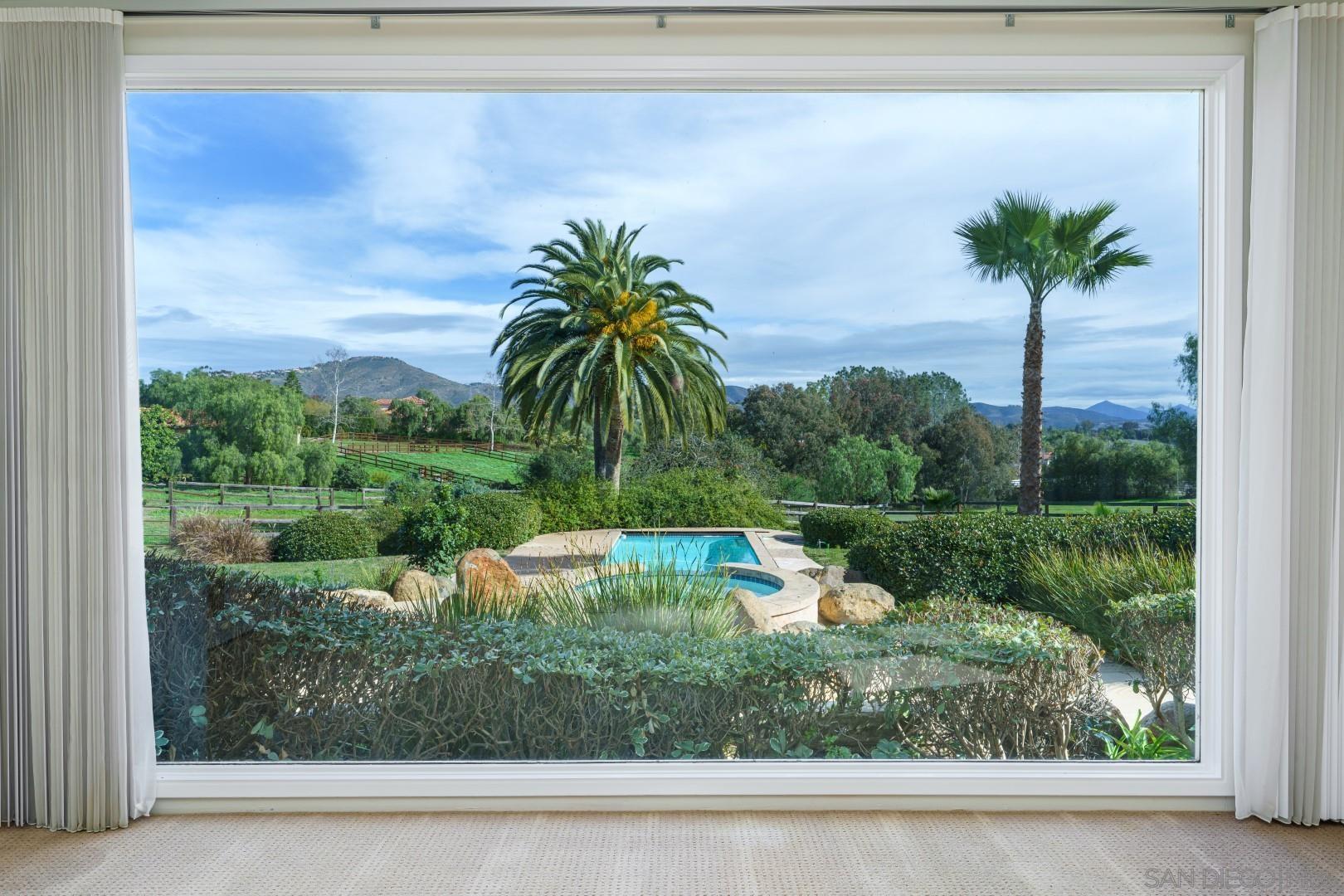 6531 Lago Lindo Rancho Santa Fe, CA 92067 - Photo 1 of 54 a view of a swimming pool with a yard and palm trees