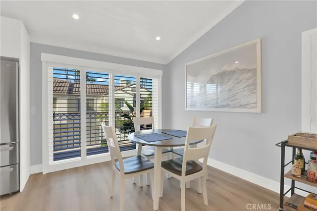 a kitchen with stainless steel appliances kitchen island granite countertop a dining table chairs sink refrigerator and cabinets