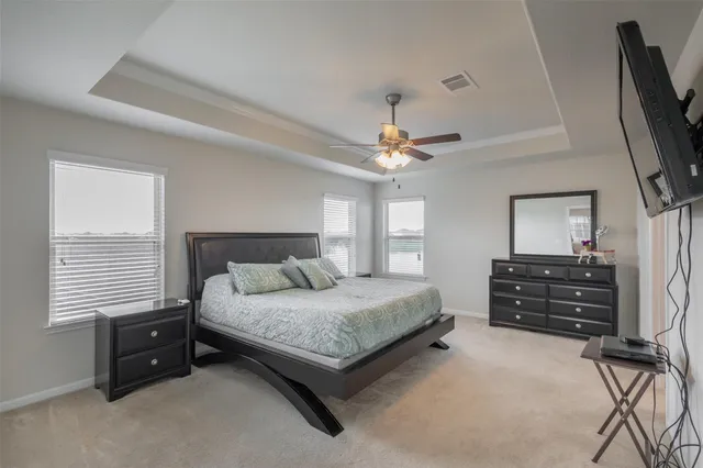 a bedroom with a bed and a flat tv screen on a dresser