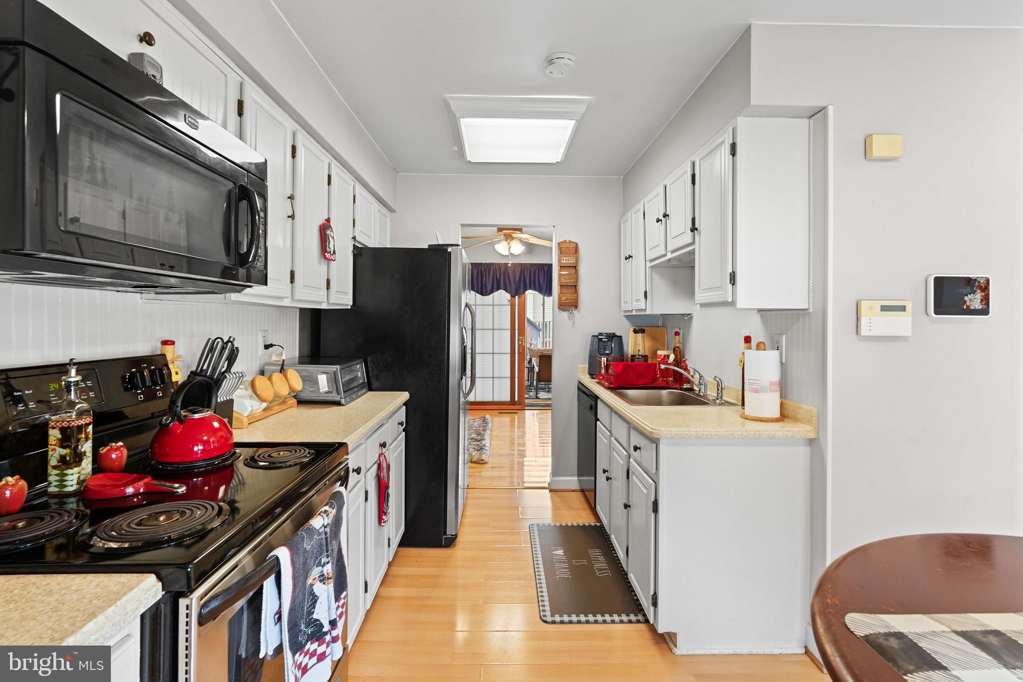 5210 Vienna Drive Clinton, MD 20735 - Photo 12 of 29 a kitchen with stainless steel appliances a stove refrigerator microwave and cabinets