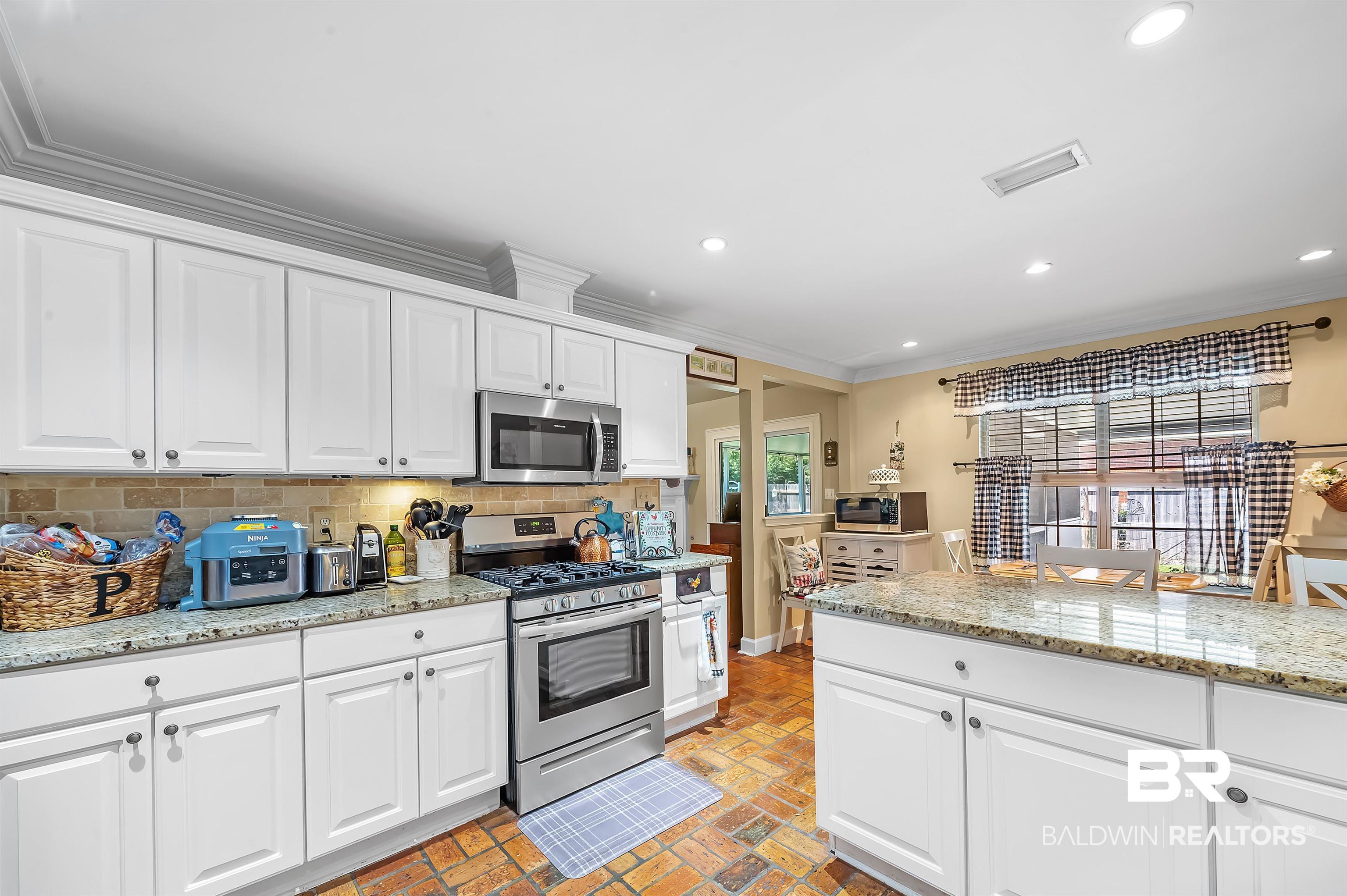 9901 Glover Court Fairhope, AL 36532 - Photo 14 of 52 Kitchen featuring stainless steel appliances, white cabinetry, plenty of natural light, and backsplash