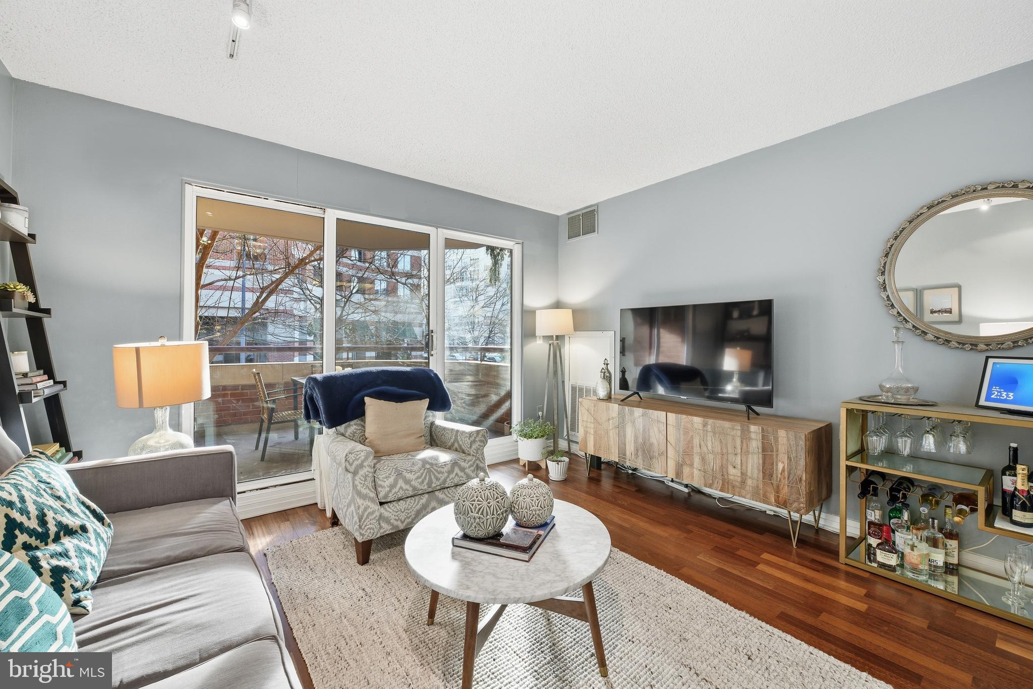 2301 N Street Northwest, Unit 212 Washington, DC 20037 - Photo 3 of 23 a living room with furniture a flat screen tv and a large window
