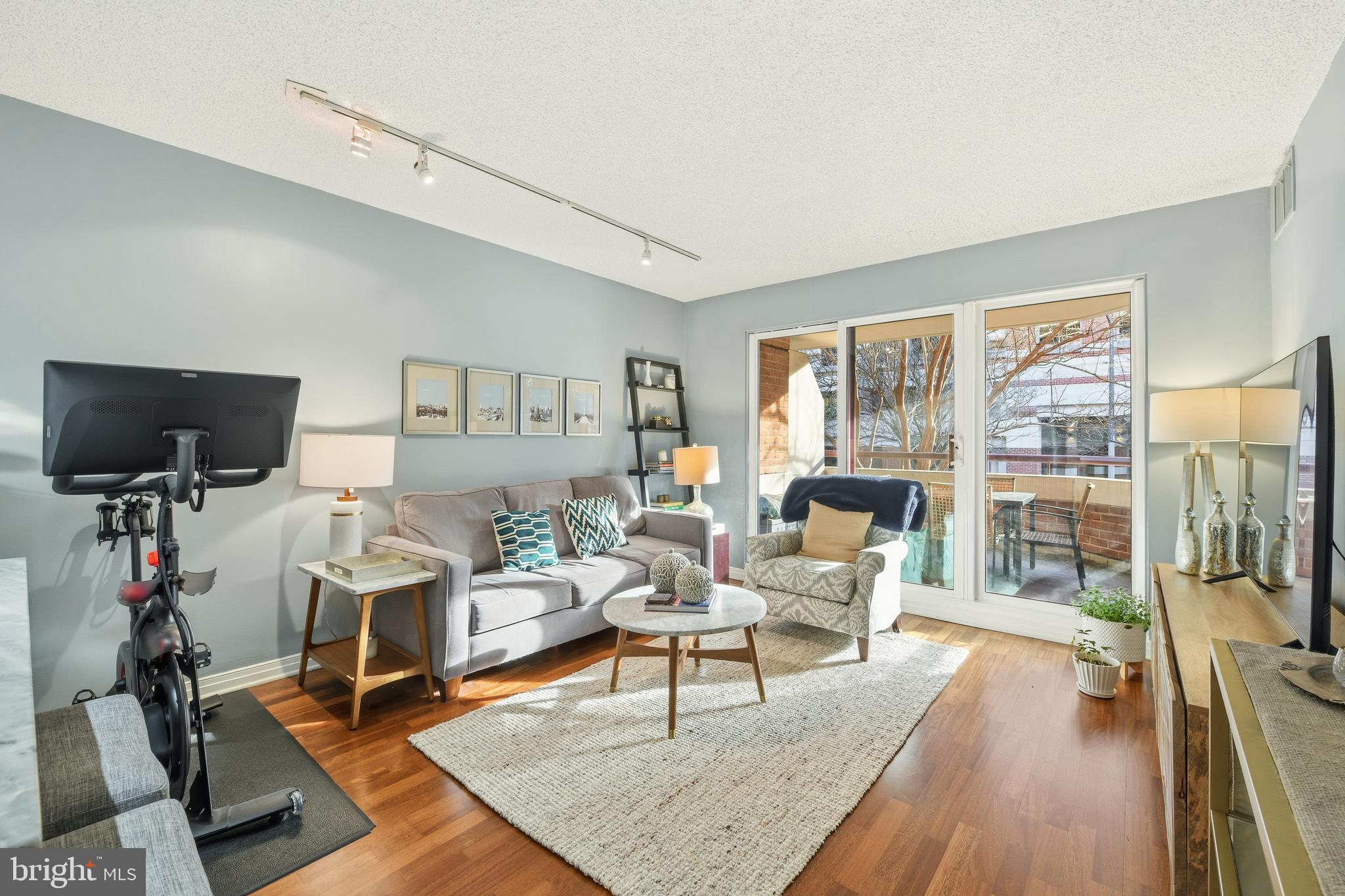 2301 N Street Northwest, Unit 212 Washington, DC 20037 - Photo 4 of 23 a living room with furniture a flat screen tv and a floor to ceiling window