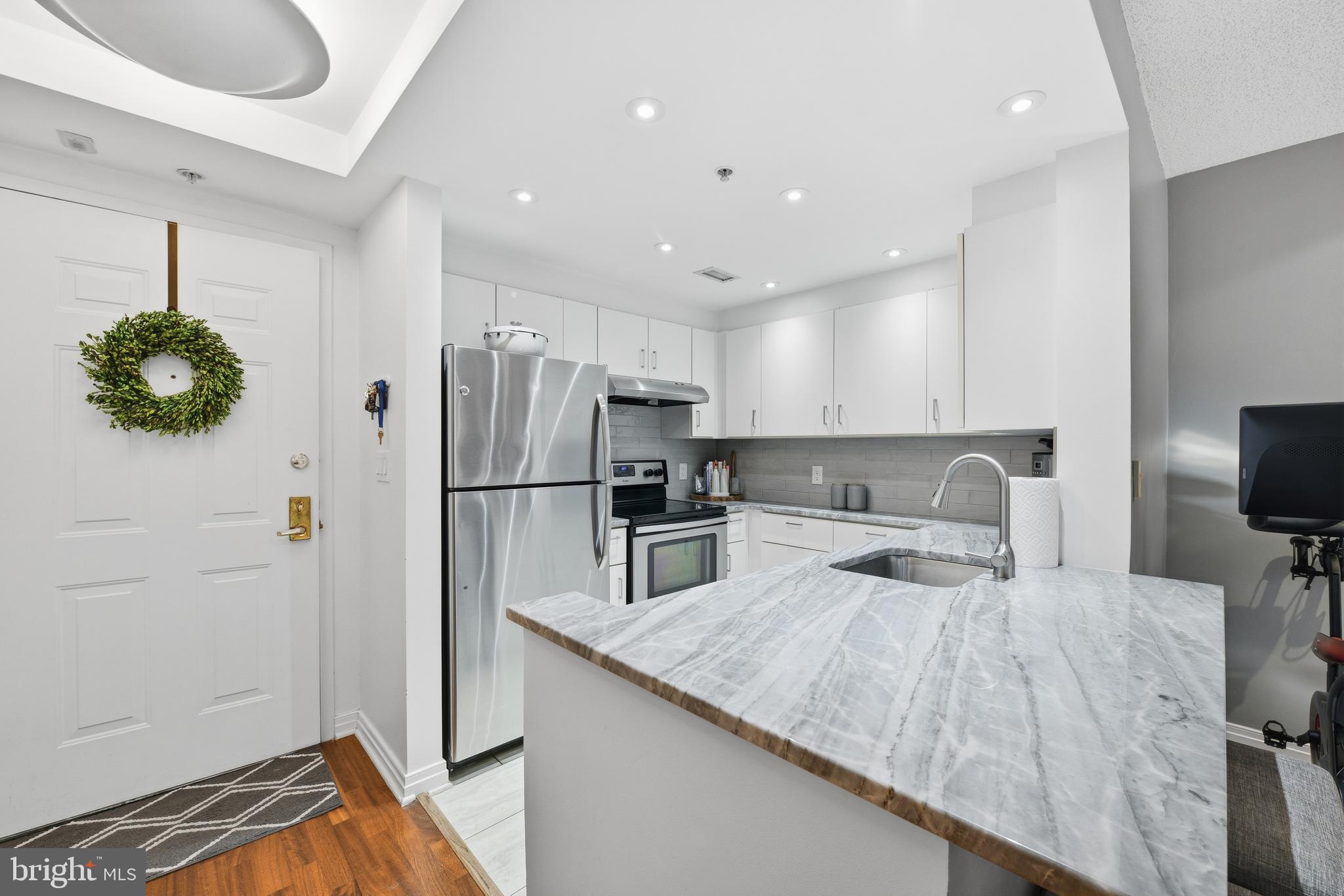 2301 N Street Northwest, Unit 212 Washington, DC 20037 - Photo 5 of 23 a kitchen with kitchen island a counter top space appliances and cabinets
