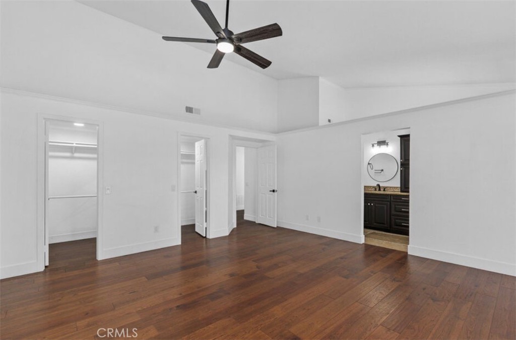 30894 Wellington Circle Temecula, CA 92591 - Photo 15 of 28 an empty room with wooden floor ceiling fan and windows
