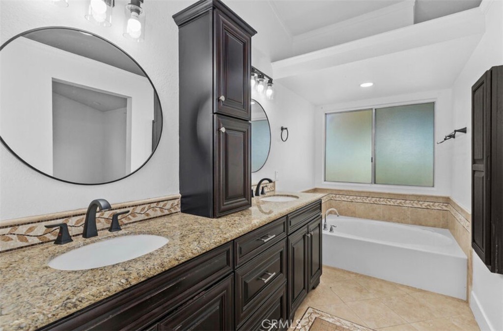 30894 Wellington Circle Temecula, CA 92591 - Photo 17 of 28 a bathroom with a granite countertop tub sink and mirror