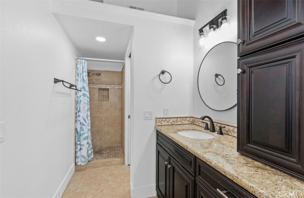 30894 Wellington Circle Temecula, CA 92591 - Photo 18 of 28 a bathroom with a granite countertop sink and a mirror
