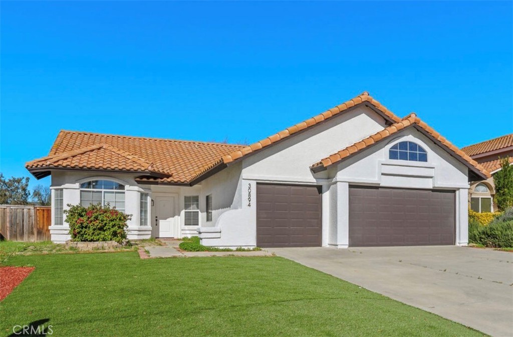 30894 Wellington Circle Temecula, CA 92591 - Photo 2 of 28 a front view of a house with a garden and yard
