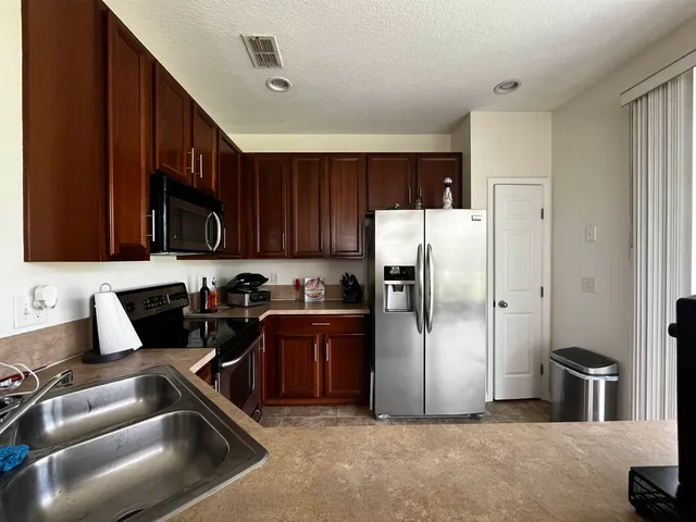 a kitchen with stainless steel appliances granite countertop a refrigerator and a sink