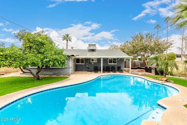 a view of an house with swimming pool and yard