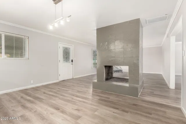 an empty room with wooden floor and fireplace
