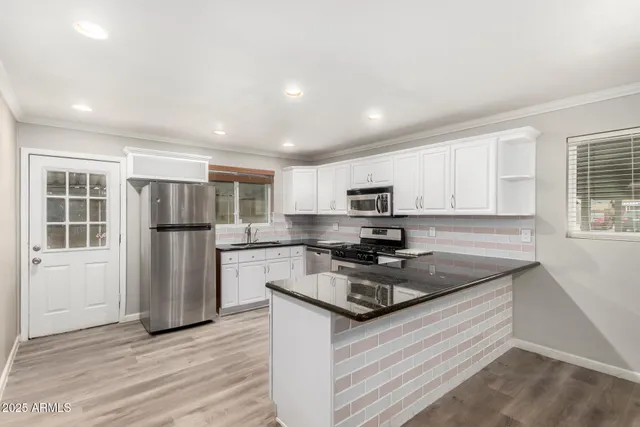 a kitchen with stainless steel appliances granite countertop a refrigerator sink and stove
