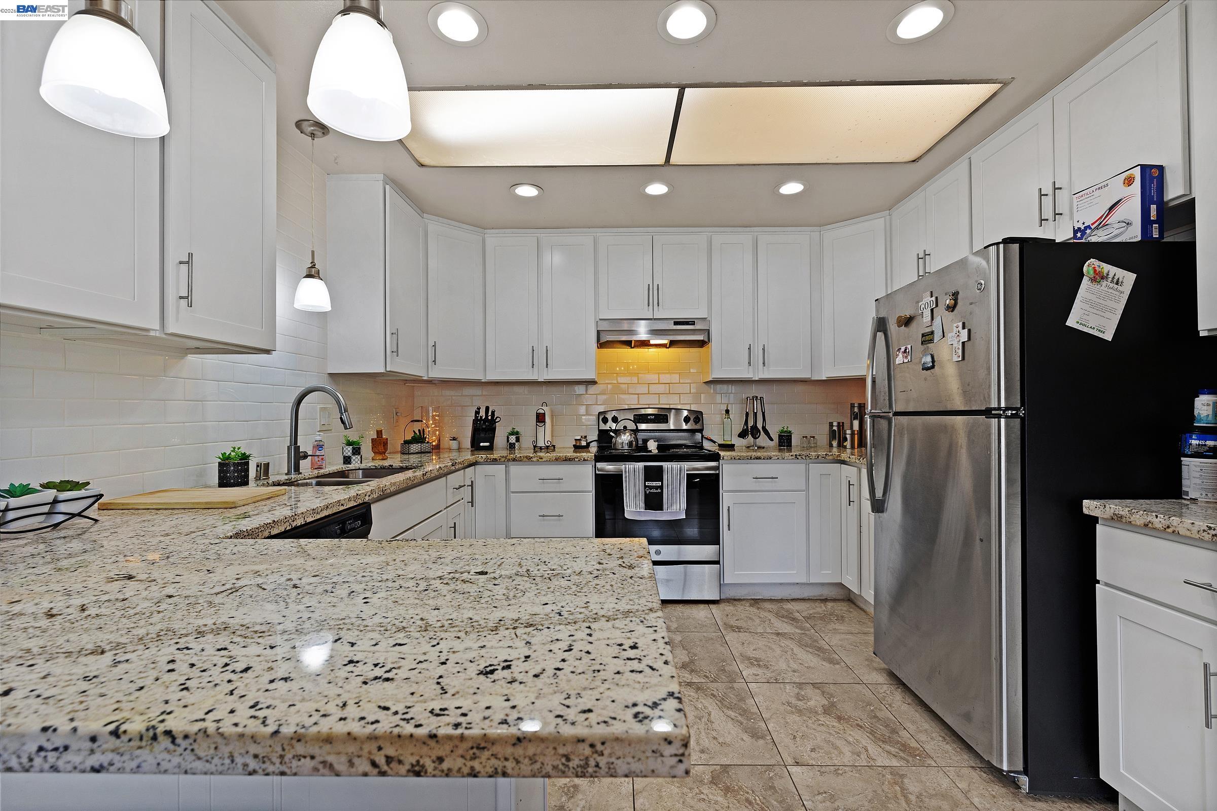 30236 Vanderbilt Street Hayward, CA 94544 - Photo 11 of 46 a kitchen with stainless steel appliances granite countertop a refrigerator a sink a stove a microwave and island