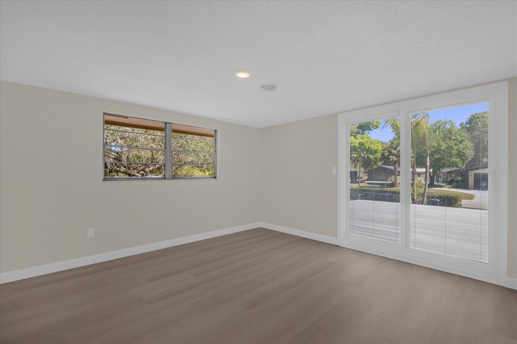 1610 Glenwood Road DeLand, FL 32720 - Photo 15 of 35 a view of an empty room with wooden floor and a window