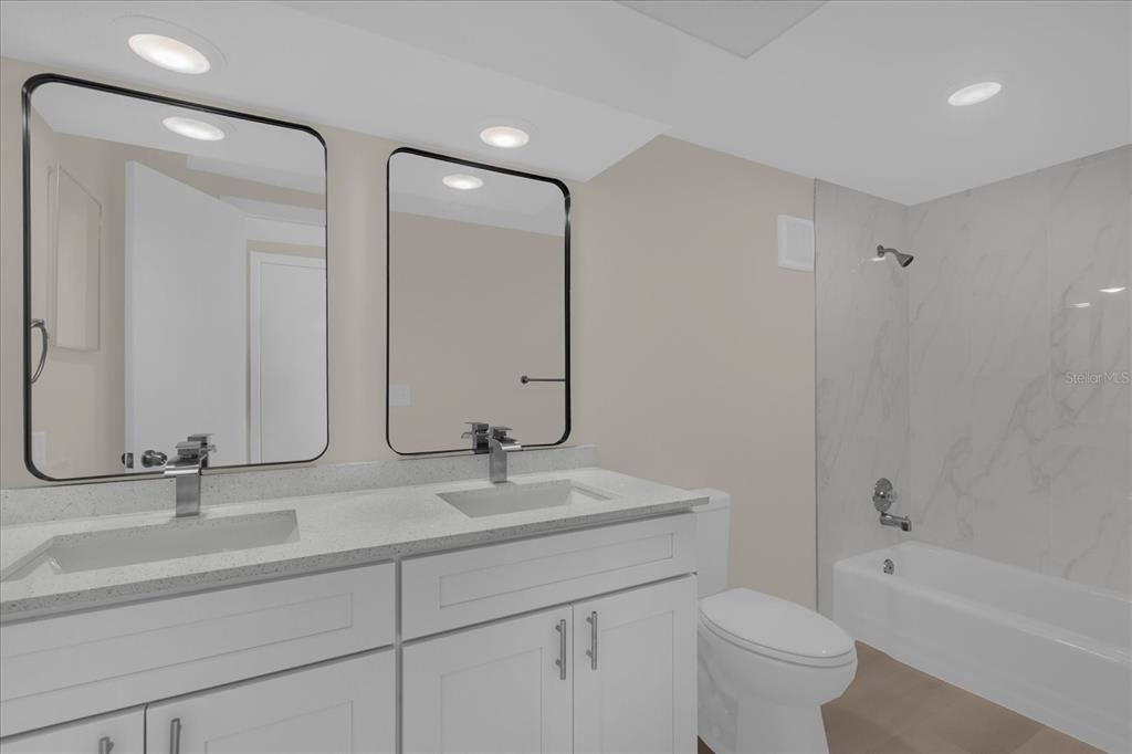 1610 Glenwood Road DeLand, FL 32720 - Photo 21 of 35 a bathroom with a double vanity sink toilet and shower