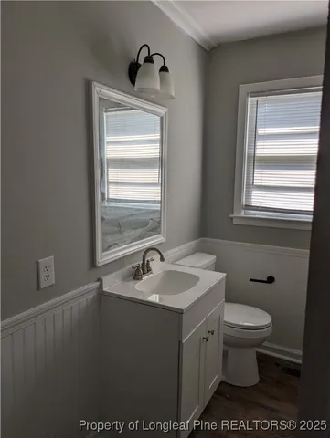 a bathroom with a sink a toilet and a window