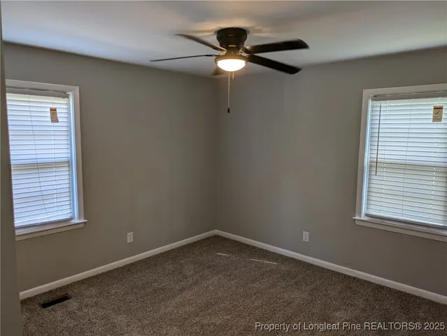 an empty room with a window and a fan
