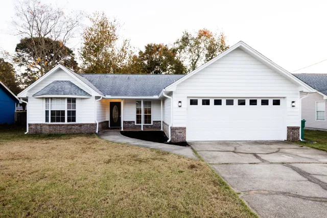 a view of a house with a yard and fence