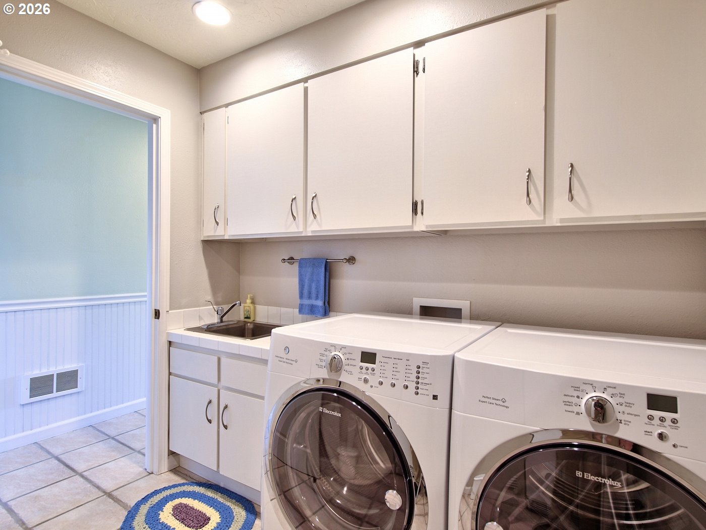 5185 Main Street Bay City, OR 97107 - Photo 37 of 48 a view of washer and dryer with kitchen in the background
