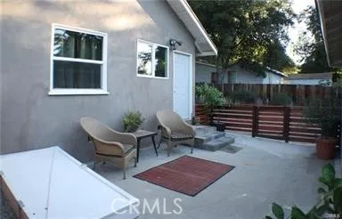 a backyard of a house with barbeque oven and outdoor seating