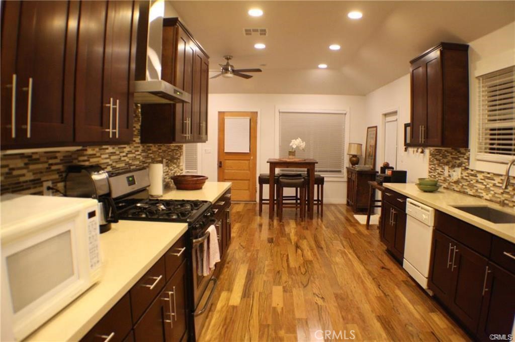 686 Atchison Street Pasadena, CA 91104 - Photo 2 of 11 a kitchen with counter top space a sink wooden floor and stainless steel appliances