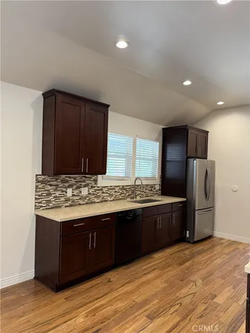 a kitchen with stainless steel appliances granite countertop a stove a refrigerator and a wooden cabinets