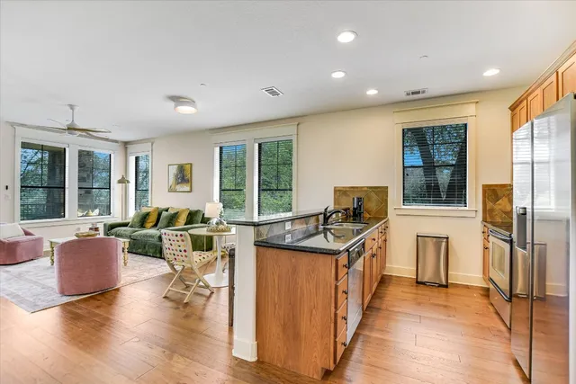 a living room with furniture a flat screen tv and large window