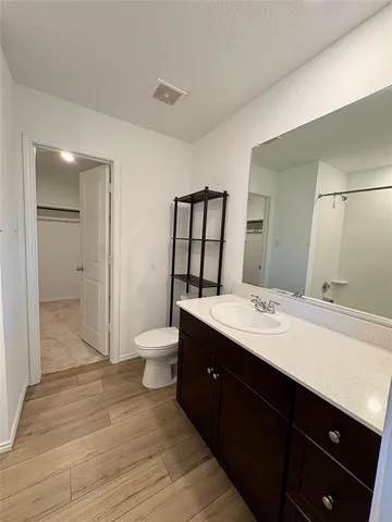 a spacious bathroom with a double vanity sink toilet mirror and shower