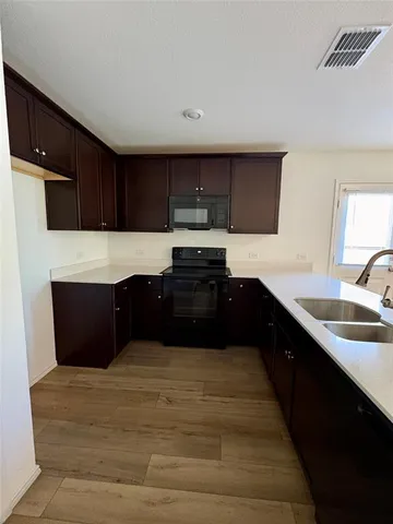 a kitchen with kitchen island granite countertop a refrigerator and a sink