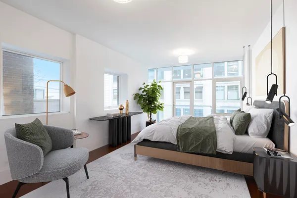 a bedroom with a bed couch and a large window