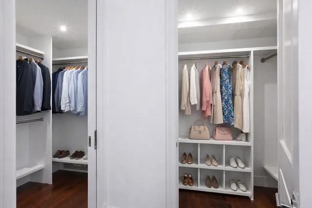 a view of walk in closet with clothes and shoes