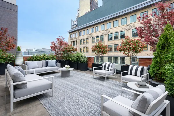 a view of a patio with couches table and chairs and potted plants