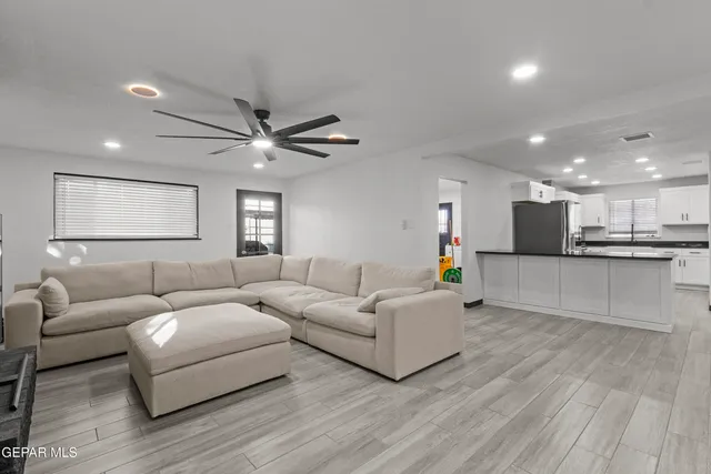 a living room with furniture and a ceiling fan