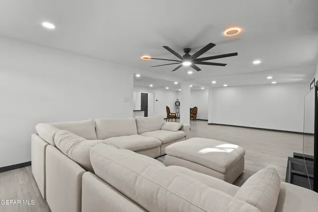 a living room with furniture and a ceiling fan