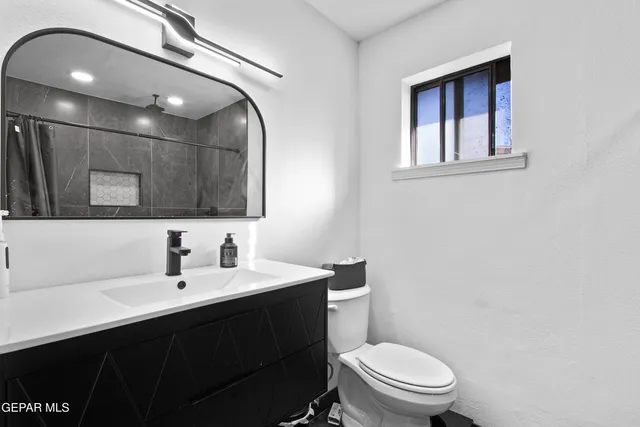 a bathroom with a sink vanity mirror and toilet