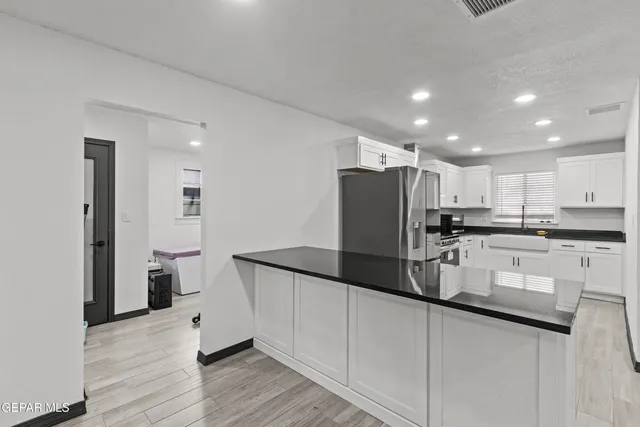 a kitchen with refrigerator and cabinets