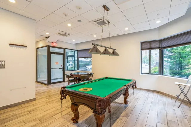 a room with pool table and windows