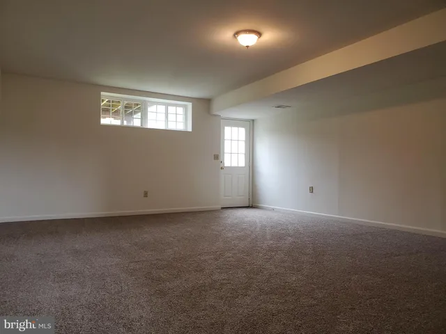 an empty room with windows and mirror