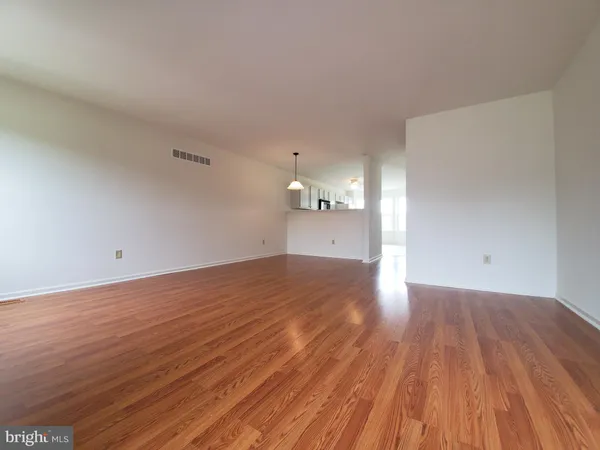 a view of empty room with wooden floor