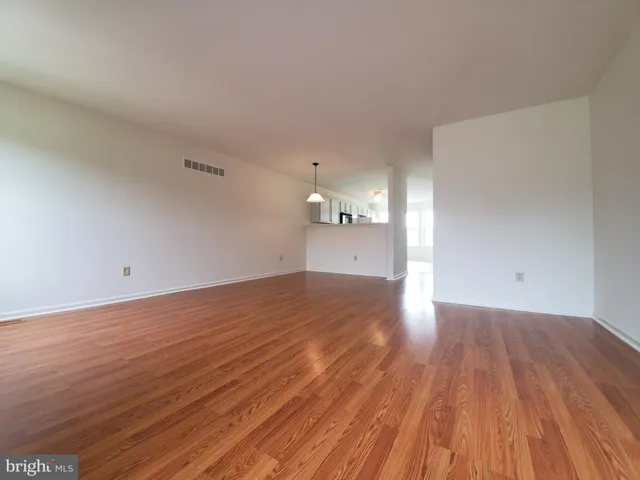 a view of empty room with wooden floor
